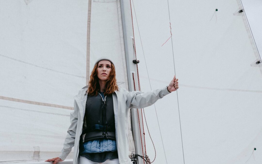 Woman with a serious face on a sailboat looking at the sea